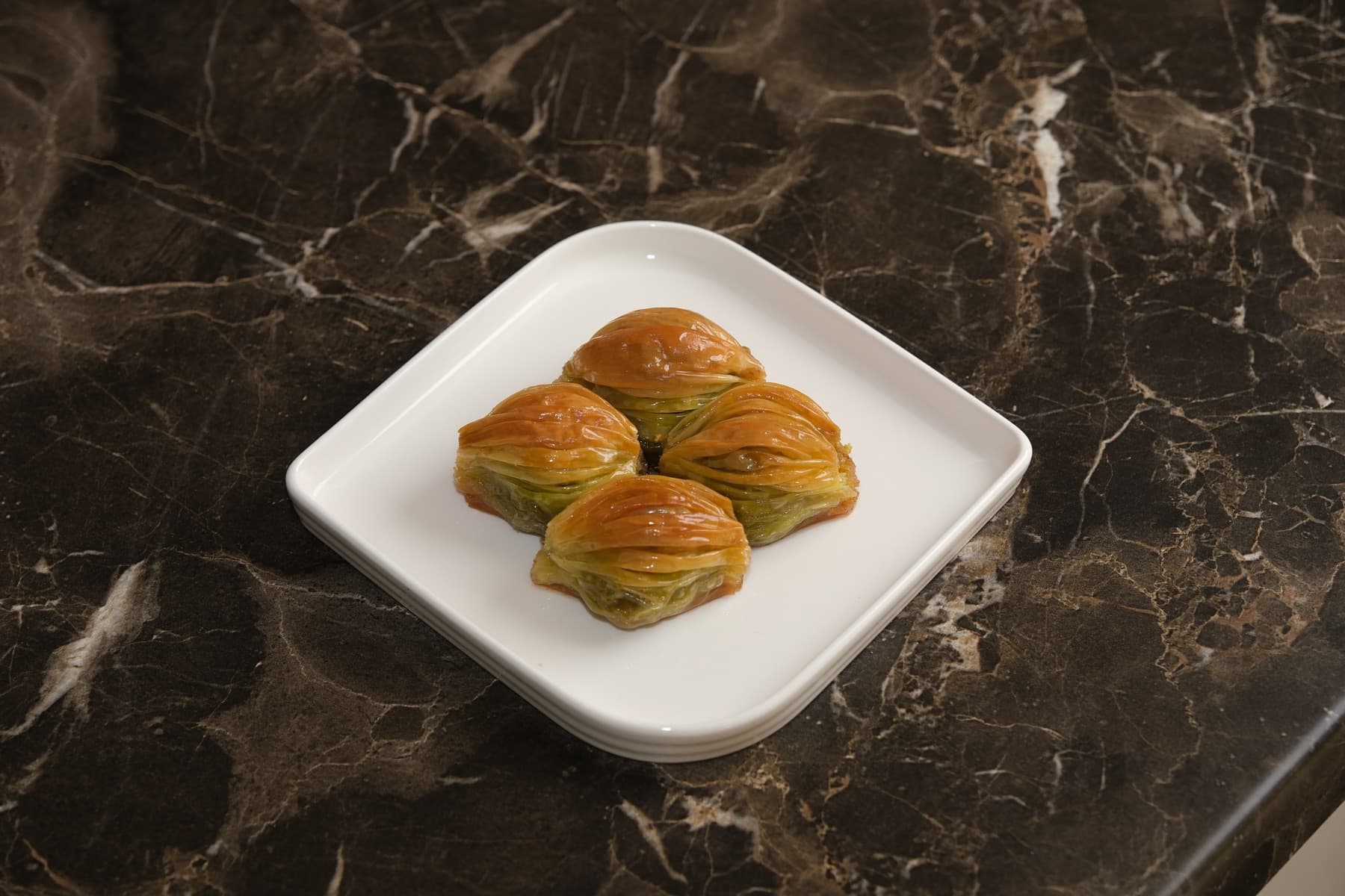 Beyaz tabakta midye baklava porsiyonu